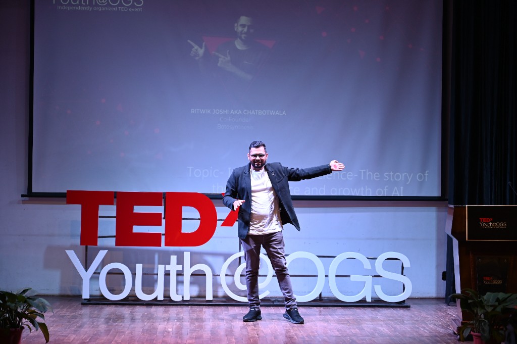 Ritwik Joshi dynamically gesturing while delivering his TEDxYouth@OGS talk on the emergence of AI.